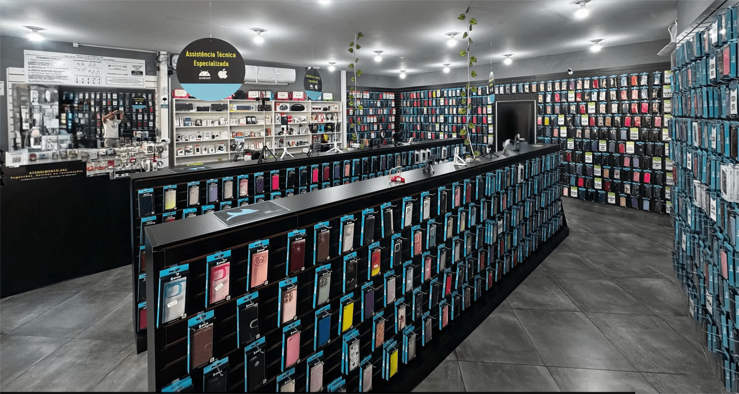 Vista ampla da Glocall Store Campinas, com a parede de capinhas e o balcão de atendimento